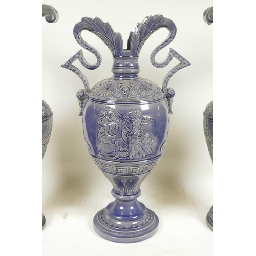 424 - A German pottery garniture consisting of two ewers and matching urn, with an indigo glaze and classi... 