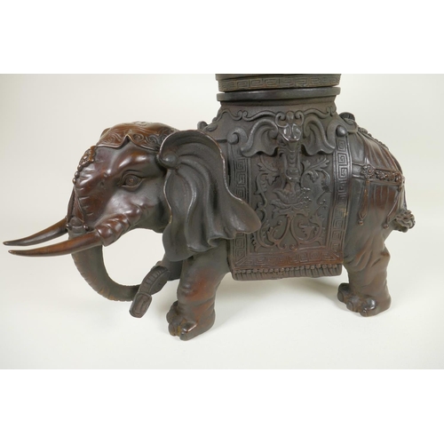 425 - An oriental bronze figure of an ornately dressed elephant with a large vase on his howdah, 16½