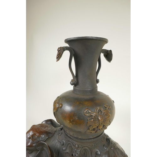 425 - An oriental bronze figure of an ornately dressed elephant with a large vase on his howdah, 16½