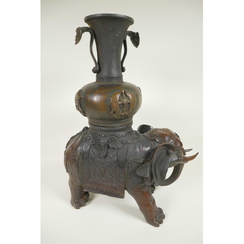 425 - An oriental bronze figure of an ornately dressed elephant with a large vase on his howdah, 16½