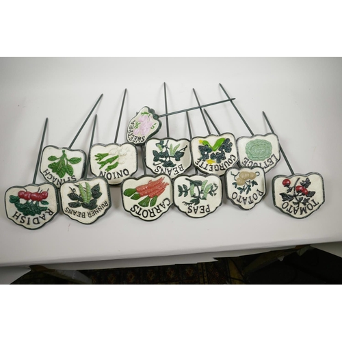 44 - A set of twelve painted cast iron vegetable and herb markers, 14