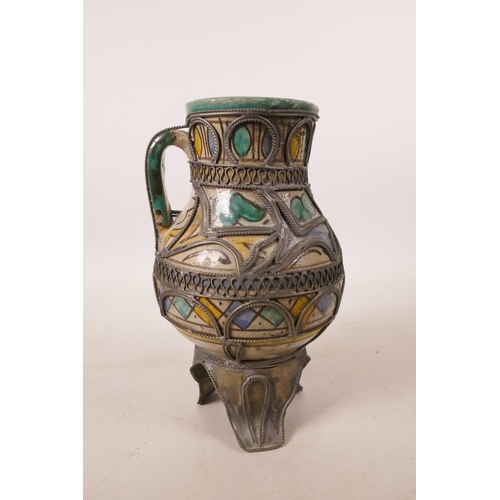 440 - A North African pottery ewer with metal mounts, A/F repair to rim, 7½