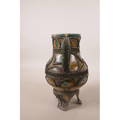 440 - A North African pottery ewer with metal mounts, A/F repair to rim, 7½