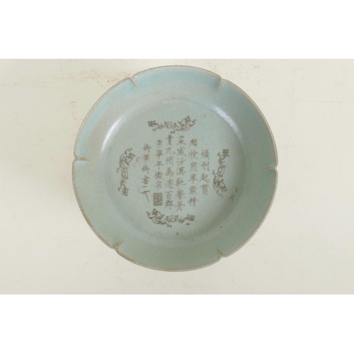 55 - A Chinese Ru ware style dish of lobed form with engraved character inscription decoration, on a carv... 