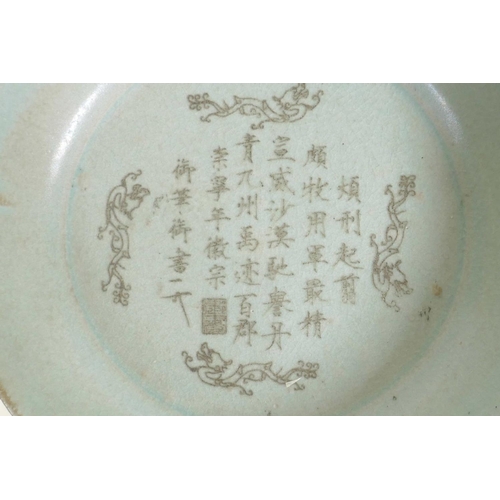 55 - A Chinese Ru ware style dish of lobed form with engraved character inscription decoration, on a carv... 