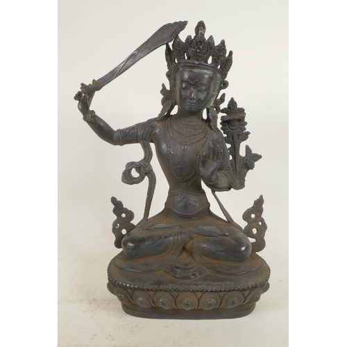 59 - A Chinese bronze figure of a Buddhist deity holding a sword and seated in meditation on a lotus thro... 