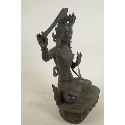 59 - A Chinese bronze figure of a Buddhist deity holding a sword and seated in meditation on a lotus thro... 