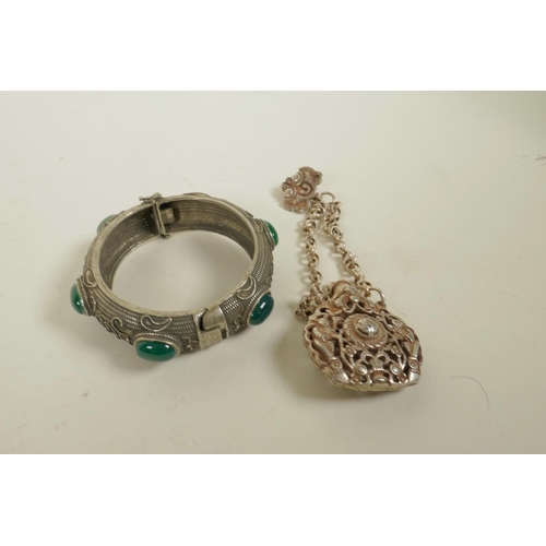 628 - A Chinese white metal bangle set with green jade stones and a white metal scent holder pendant, bang... 