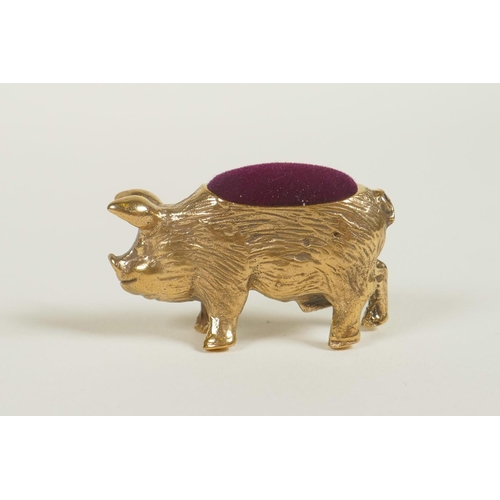 648 - A miniature brass pincushion in the form of a pig, 1½