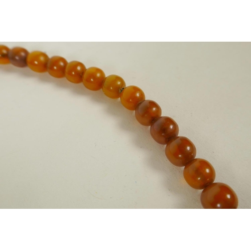 659 - An amber beaded necklace, and a silver and faux amber bracelet, 16