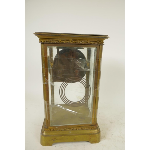 669 - An American brass cased four glass mantel clock with twin train movement striking on a gong, white e... 