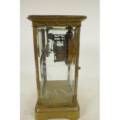 669 - An American brass cased four glass mantel clock with twin train movement striking on a gong, white e... 