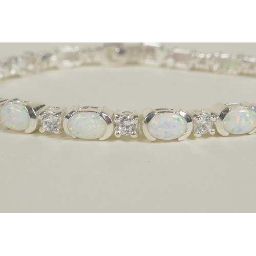 673 - A silver bracelet set with alternating cubic zirconium and opalite, 7