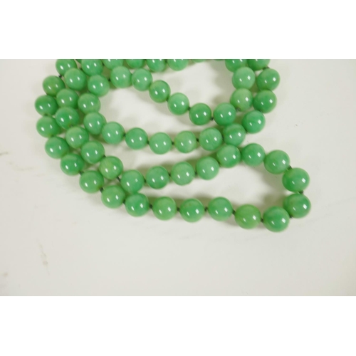 678 - A string of light green jade beads, 34