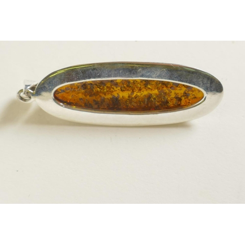 704 - A silver mounted faux amber pendant, 2½