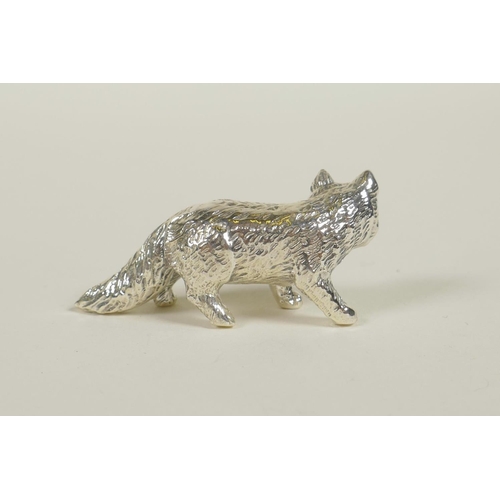 708 - A sterling silver figure of a fox with ruby set eyes, 1½