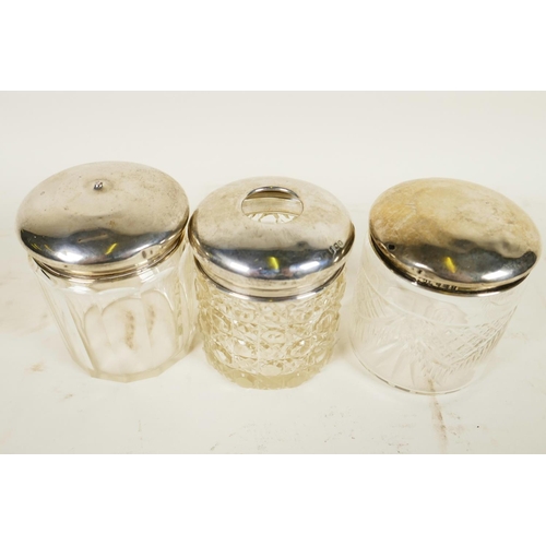 709 - Three silver lidded glass dressing table jars, silver weight 29.9 grams