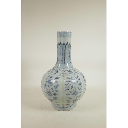 75 - A Chinese Ming style blue and white porcelain bottle vase of ribbed form, decorated with flowers, 14... 