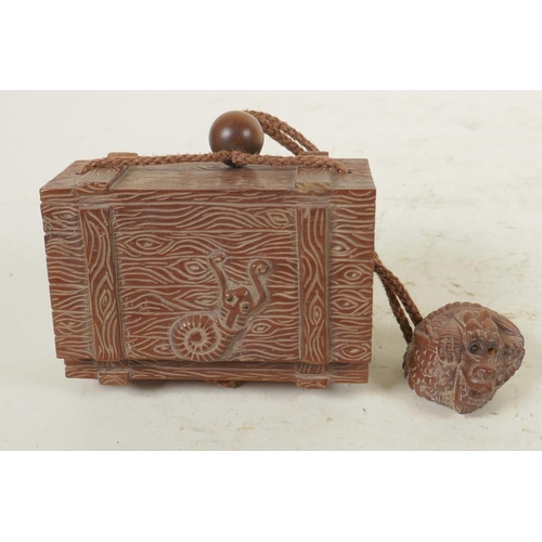 84 - A Japanese wood inro carved in the form of a trunk with a snail, with a carved dragon toggle, 3½