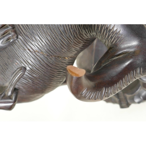 91 - An Oriental carved hardwood figure of a man seated on a buffalo, 23