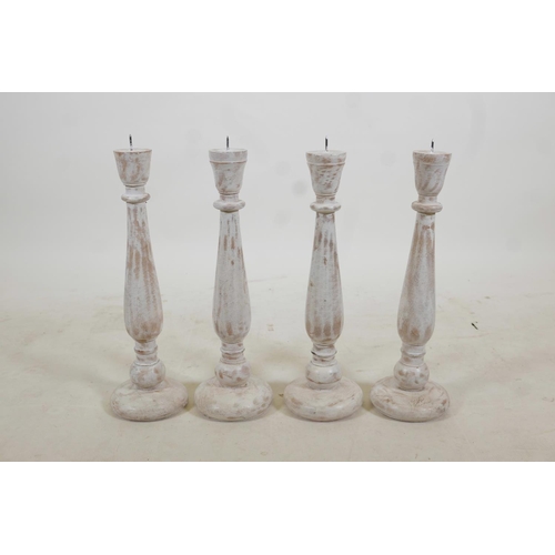 96 - A set of four turned and painted wood pricket candlesticks with a distressed finish, 19