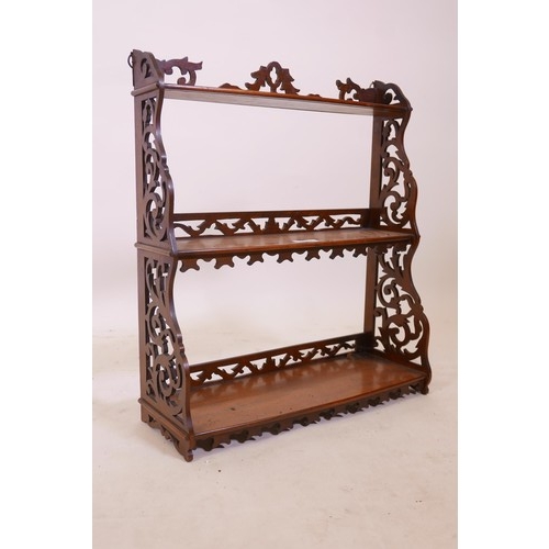 1288 - A C19th walnut hanging shelf, with bowfronted shelves and fretwork sides, losses, 18