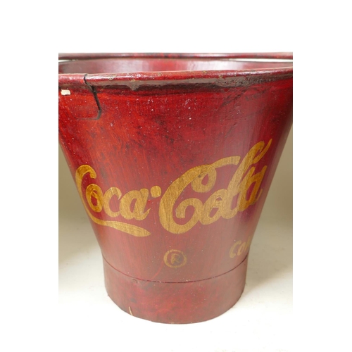 31 - A set of three graduated metal buckets painted in red and with the Coca-Cola emblem, largest 14