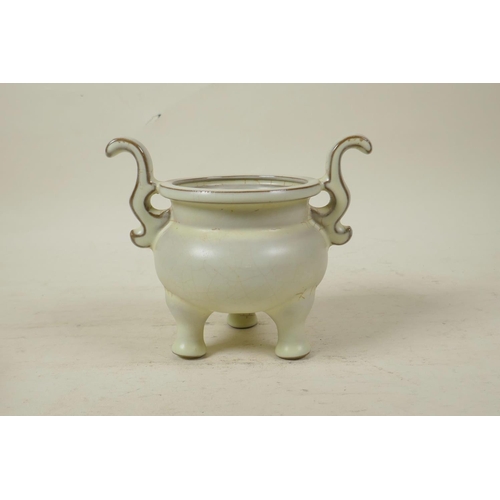 55 - A Chinese Song style cream glazed porcelain censer with two handles, raised on tripod feet, seal mar... 