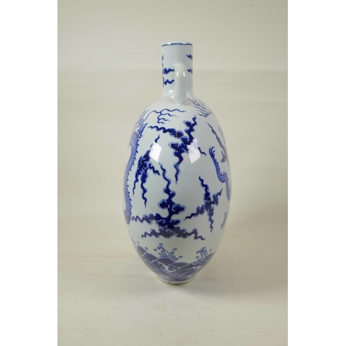 58 - A Chinese blue and white porcelain two handled moon flask decorated with a dragon and the flaming pe... 