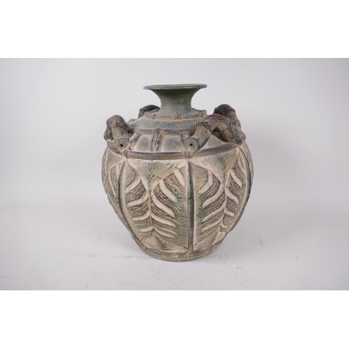 17 - An Oriental pottery vase with four handles modelled as bamboo, the body carved with monstera leaves,... 