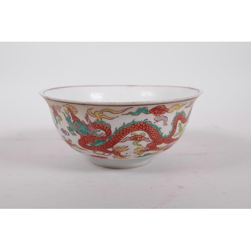 195 - A Chinese polychrome porcelain rice bowl decorated with dragons to exterior and a phoenix to the bow... 