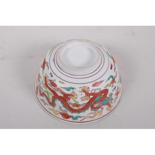 195 - A Chinese polychrome porcelain rice bowl decorated with dragons to exterior and a phoenix to the bow... 