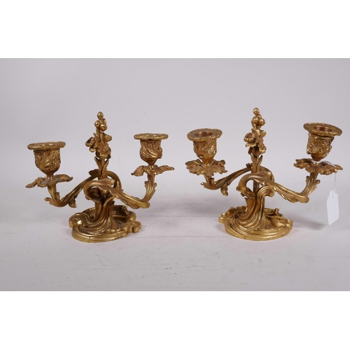 27 - A pair of gilt brass two branch rococo style dwarf candlesticks, 6