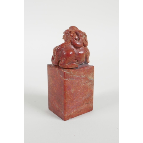 38 - A Chinese red soapstone seal with a carved kylin knop, 3