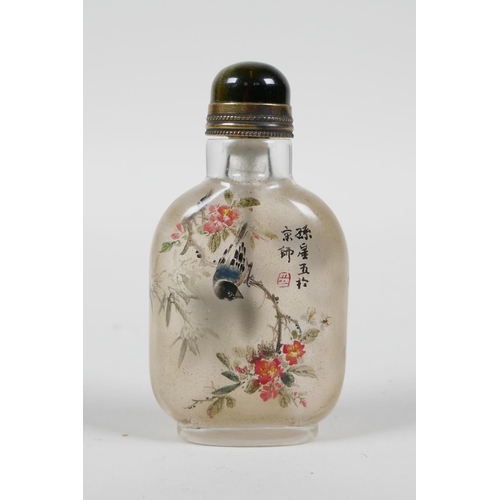 103 - A Chinese reverse decorated glass snuff bottle depicting birds perched on branches in bloom, 3