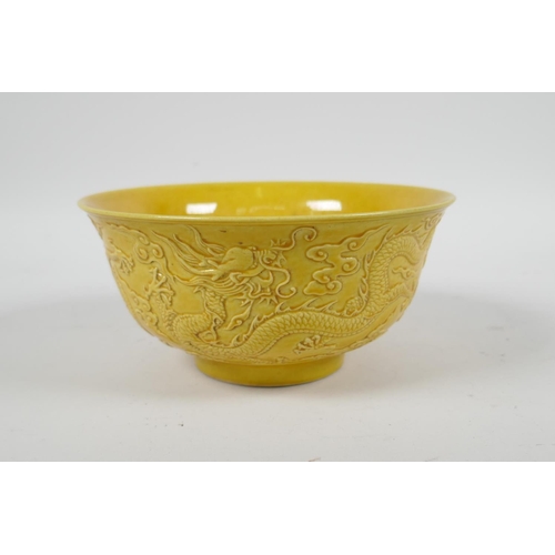 105 - A Chinese yellow ground porcelain rice bowl with raised dragon decoration, 6 character mark to base,... 