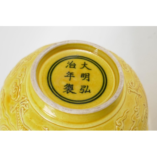 105 - A Chinese yellow ground porcelain rice bowl with raised dragon decoration, 6 character mark to base,... 