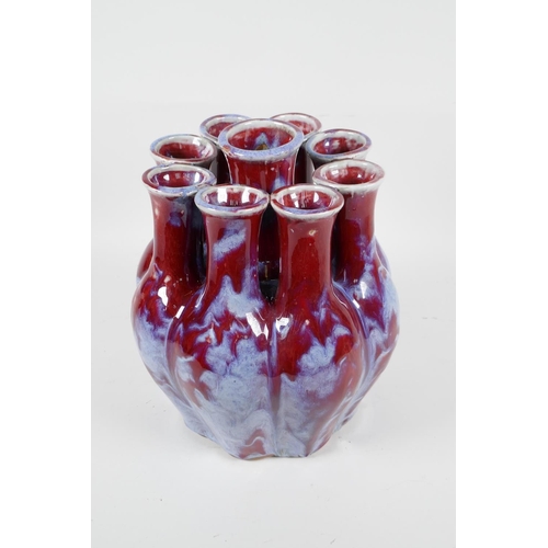 111 - A Chinese flambe glazed porcelain nine section tulip vase, 9½