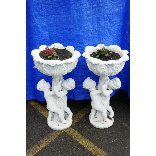 1199 - A pair of painted concrete raised garden planters, the planters held aloft by two cherubs, 36