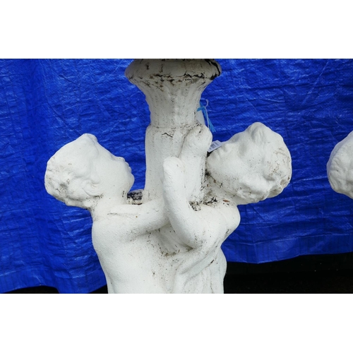 1199 - A pair of painted concrete raised garden planters, the planters held aloft by two cherubs, 36