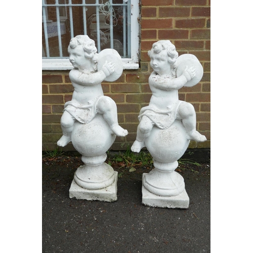 1200 - A pair of painted garden statues in the form of putti atop balls, 40