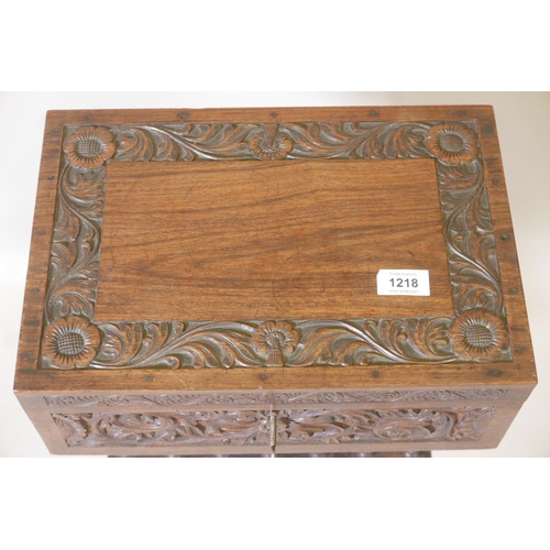 1218 - An Anglo-Indian padauk wood workbox, with carved decoration and galleried well, raised on a carved c... 