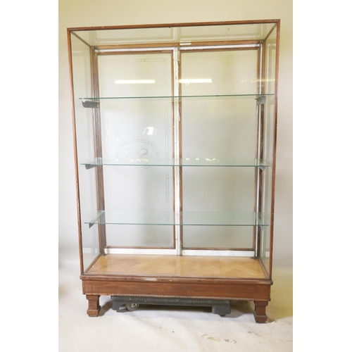 1228 - An early C20th shop display cabinet, the rear doors with etched decoration and company logo 