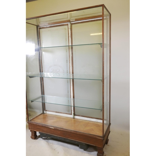 1228 - An early C20th shop display cabinet, the rear doors with etched decoration and company logo 