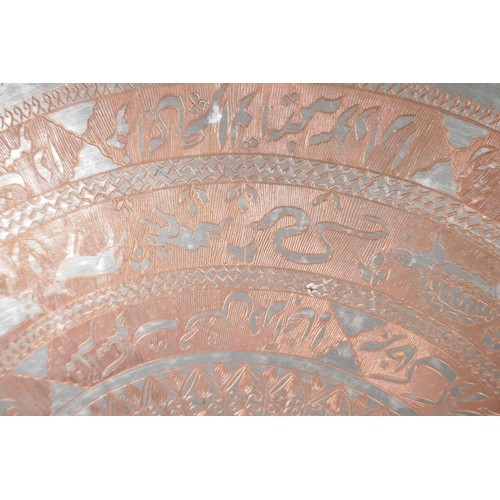 17 - An Islamic silvered cast copper tray with frilled rim engraved with animals, scrolls etc, 29