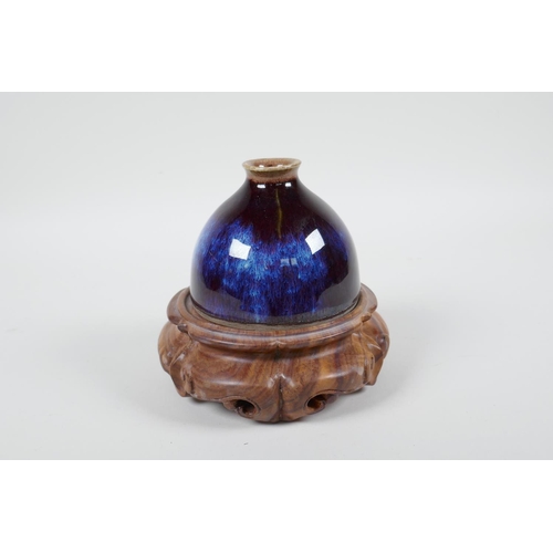 18 - A Chinese porcelain water pot with a Jun ware flambe glaze, on a carved hardwood stand, 5