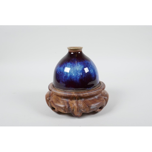 18 - A Chinese porcelain water pot with a Jun ware flambe glaze, on a carved hardwood stand, 5