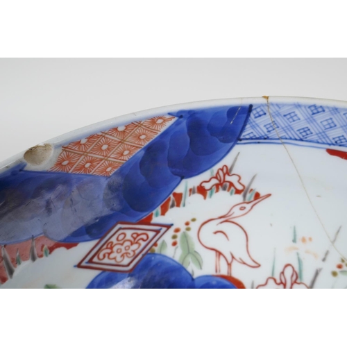 21 - A C19th Japanese Imari porcelain bowl painted with herons amongst the reeds, in traditional colours,... 