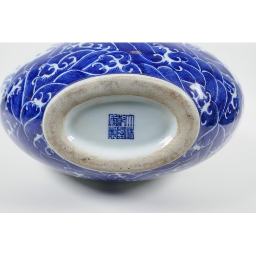 25 - A Chinese blue and white porcelain moon flask decorated with a dragon chasing the flaming pearl, sea... 