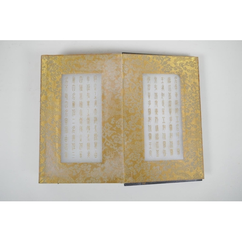 36 - A Chinese wood and material bound book containing white jade tablets with engraved and gilt characte... 